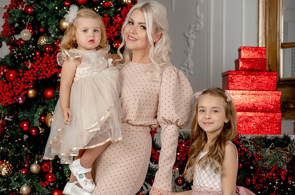 mother with daughters by christmas tree