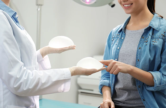 surgeon showing breast implants of different sizes