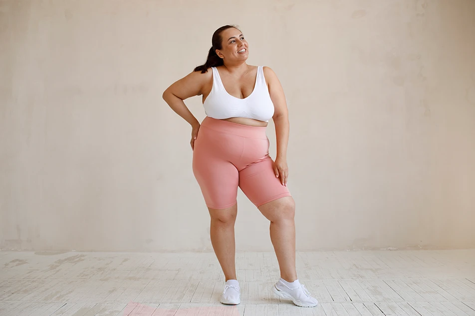plus-size woman standing and smiling in activewear