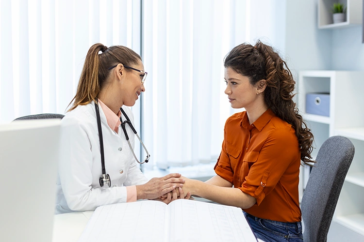 Female surgeon offering reassurance and discussing treatment options with a patient during consultation
